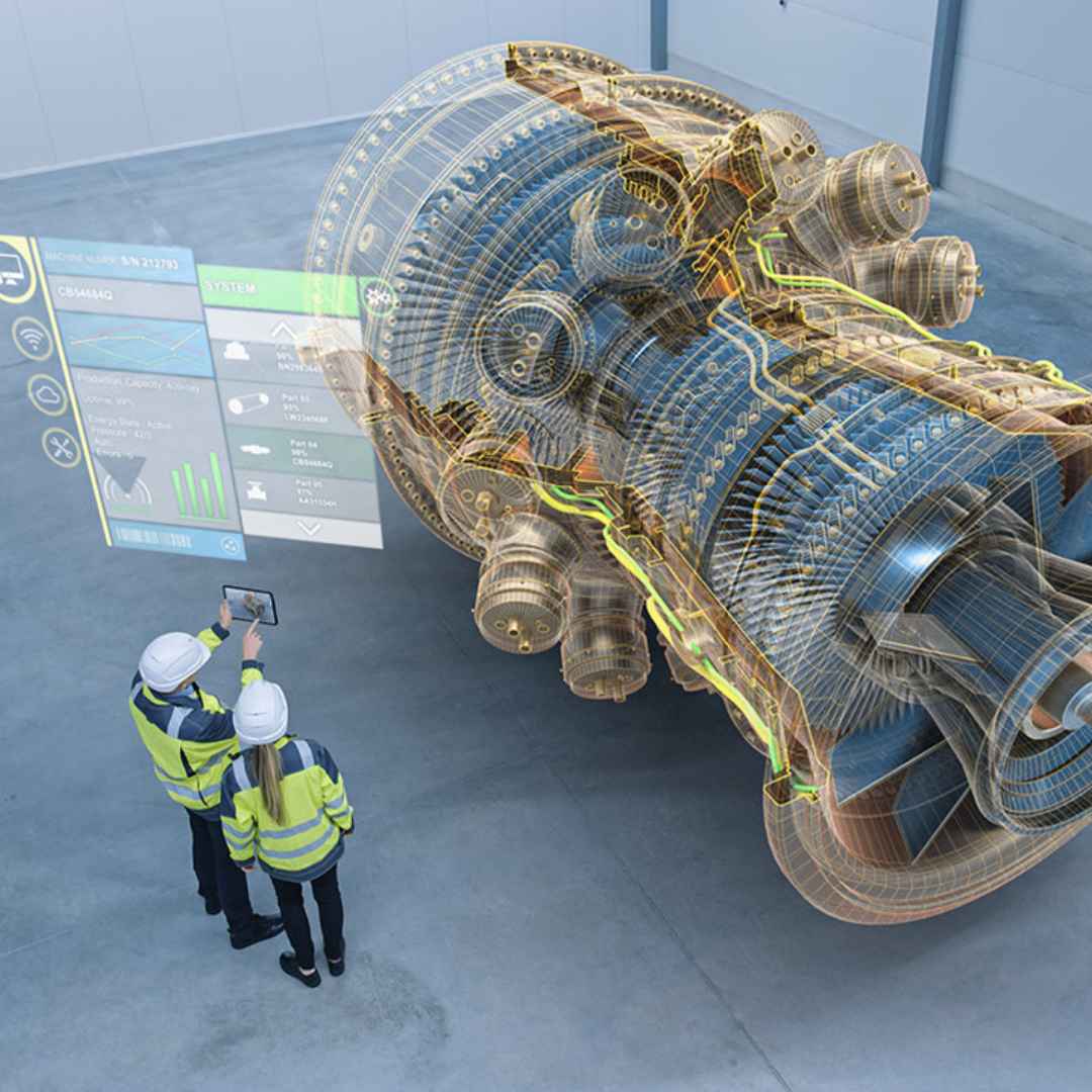 Two engineers in a room with a large mechanical engine model and digital interface.